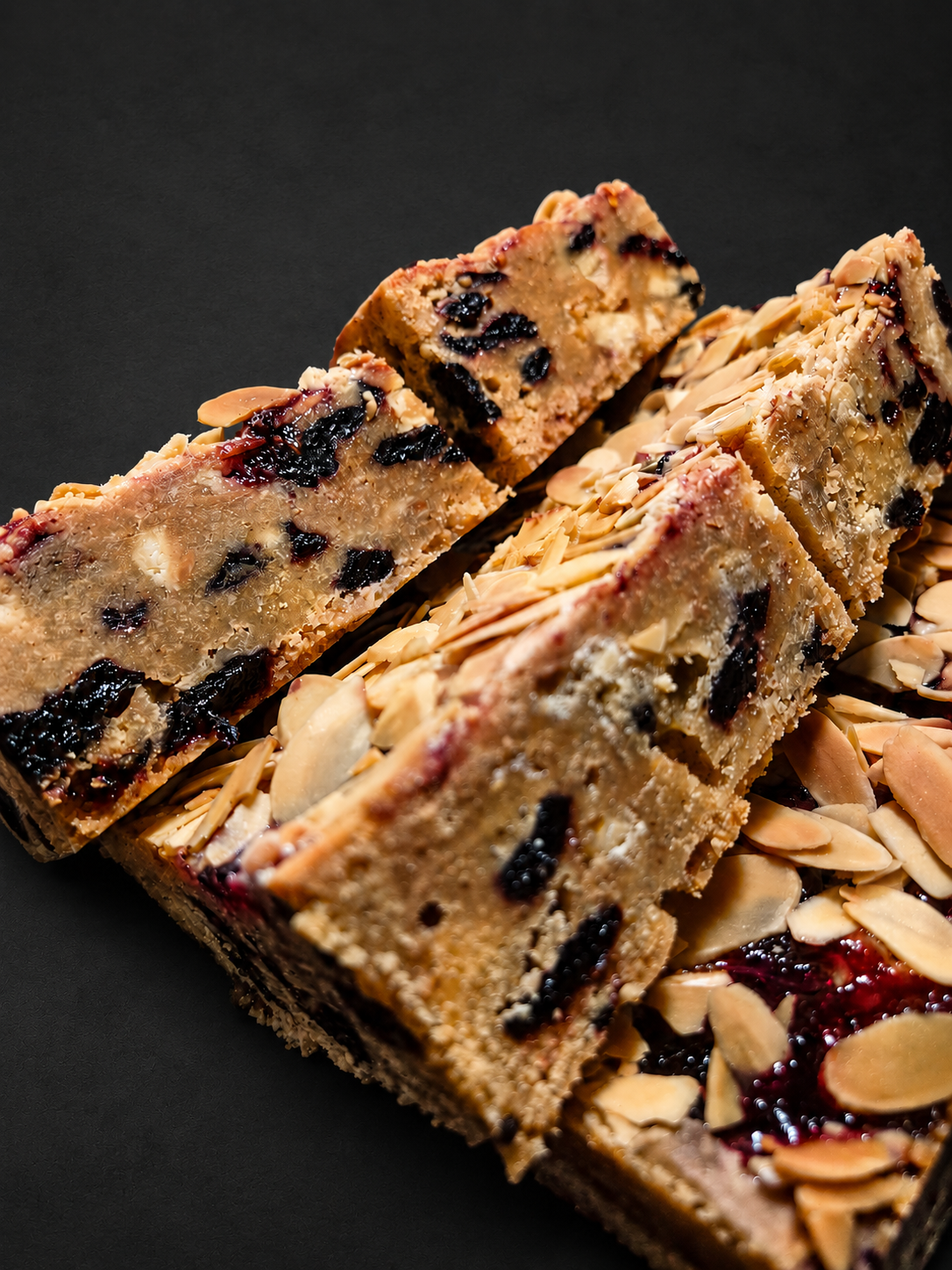 Black cherry, almond and white chocolate blondies showing the sliced centre – The Bakewell Conspiracy